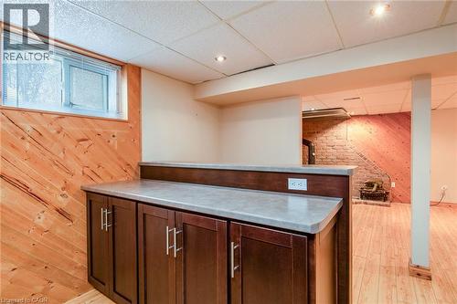 Bar area with a drop ceiling, wooden walls, light countertops, dark brown cabinets, and light wood-type flooring - 120 Fourth Avenue, Kitchener, ON - Indoor Photo Showing Other Room