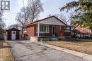 Bungalow-style house featuring brick siding, a storage unit, asphalt driveway, a porch, and a front lawn - 120 Fourth Avenue, Kitchener, ON  - Outdoor 