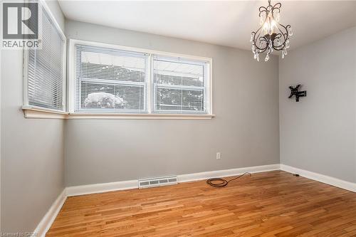Unfurnished room featuring light wood finished floors and suspended lighting - 120 Fourth Avenue, Kitchener, ON - Indoor Photo Showing Other Room