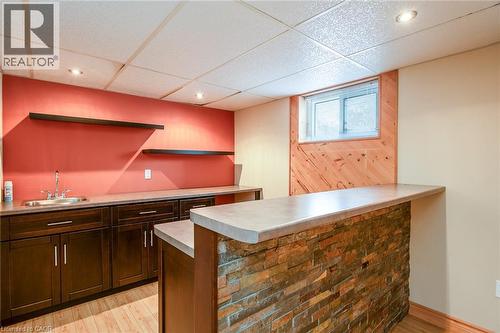 Kitchen with a drop ceiling, light countertops, dark wood finish cabinetry, a peninsula, and light wood-type flooring - 120 Fourth Avenue, Kitchener, ON - Indoor Photo Showing Other Room