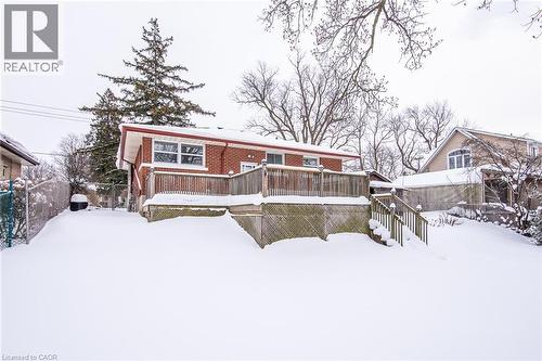 Snow covered back of property featuring a wooden deck and brick siding - 120 Fourth Avenue, Kitchener, ON - Outdoor