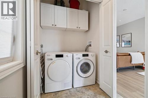Laundry area with cabinet space and independent washer and dryer - 2220 Queensway Drive Unit# 15, Burlington, ON - Indoor Photo Showing Laundry Room