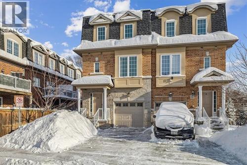 View of front of house featuring mansard roof, an attached garage, and brick siding - 2220 Queensway Drive Unit# 15, Burlington, ON - Outdoor With Facade