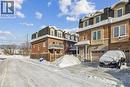 View of front of property featuring mansard roof, brick siding, and a shingled roof - 2220 Queensway Drive Unit# 15, Burlington, ON  - Outdoor With Balcony 