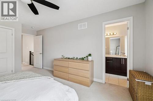 Bedroom featuring light carpet, a ceiling fan, and connected bathroom - 2220 Queensway Drive Unit# 15, Burlington, ON - Indoor Photo Showing Bedroom
