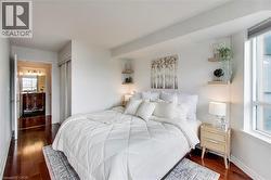 Bedroom with dark wood-type flooring, a closet, and ensuite bathroom - 