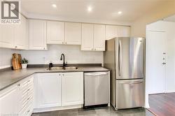 Kitchen featuring stainless steel appliances, white cabinetry, backsplash, and recessed lighting - 