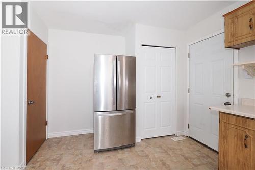 Kitchen featuring freestanding refrigerator, brown cabinets, light countertops, and stone finish flooring - 10 Balfour Crescent, Kitchener, ON - Indoor