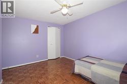 Unfurnished bedroom with parquet floors, a ceiling fan, and a closet - 