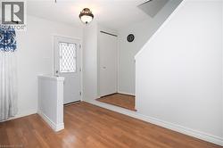 Foyer with baseboards and wood finished floors - 