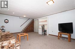 Living area featuring light carpet and stairway - 