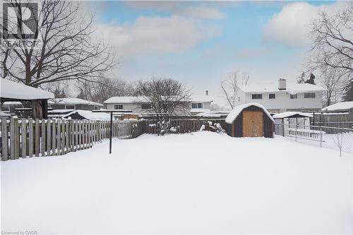 Yard covered in snow featuring a fenced backyard, a storage unit, and a residential view - 10 Balfour Crescent, Kitchener, ON - Outdoor
