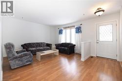 Living room featuring light wood-style flooring and baseboards - 