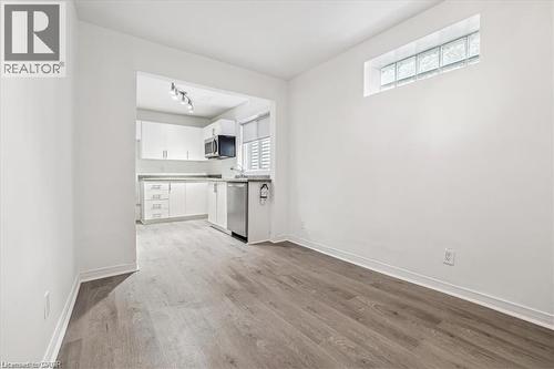 Unfurnished living room with light wood-style floors - 28 Grove Street, Hamilton, ON - Indoor Photo Showing Kitchen