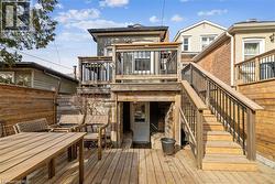 Back of property with outdoor dining space, a deck, and stairs - 