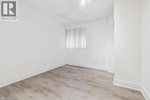 Empty room featuring light wood-style floors and baseboards - 28 Grove Street, Hamilton, ON - Indoor Photo Showing Other Room