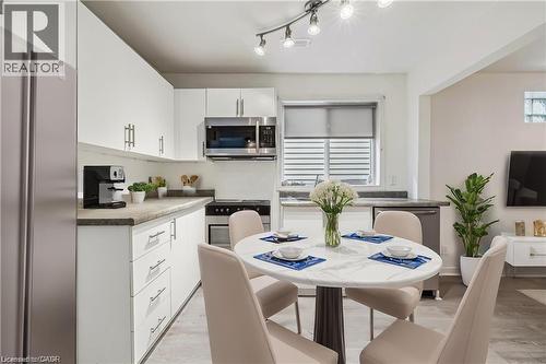 Kitchen with appliances with stainless steel finishes, white cabinetry, and light wood-style flooring - 28 Grove Street, Hamilton, ON - Indoor