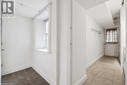 Corridor with dark tile patterned flooring and baseboards - 28 Grove Street, Hamilton, ON - Indoor Photo Showing Other Room