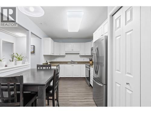 Walk-through Kitchen with stainless steel appliances and room for a dining table - 1966 Durnin Road Unit# 105, Kelowna, BC - Indoor