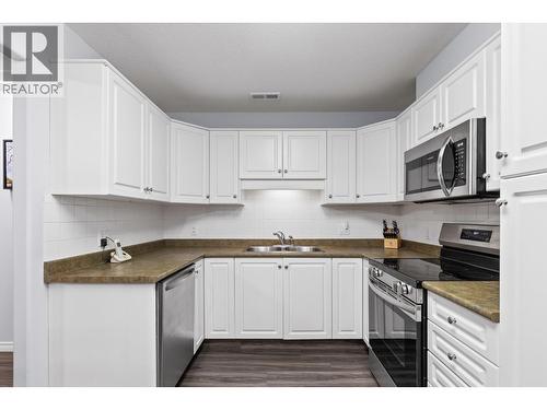 Walk-through Kitchen with stainless steel appliances - 1966 Durnin Road Unit# 105, Kelowna, BC - Indoor Photo Showing Kitchen With Double Sink
