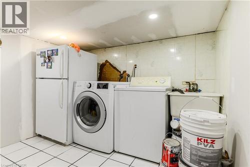 Washroom featuring washing machine and dryer and light tile patterned floors - 126 Tisdale Street N, Hamilton, ON - Indoor Photo Showing Laundry Room