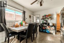 Dining room featuring ceiling fan, wainscoting, and light tile patterned floors - 