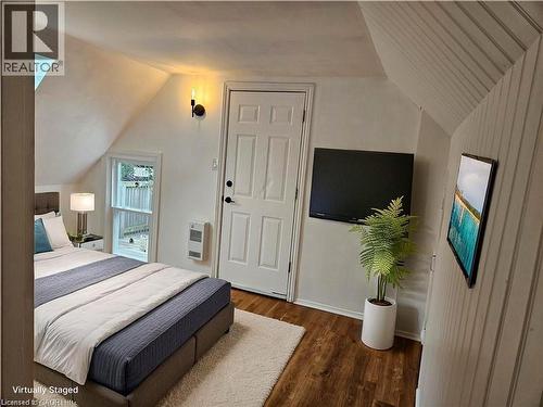 Bedroom with lofted ceiling, dark wood-type flooring, and heating unit - 180 Emerald Street S, Hamilton, ON - Indoor Photo Showing Bedroom