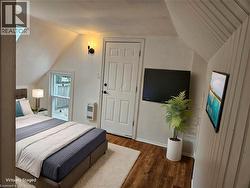Bedroom with lofted ceiling, dark wood-type flooring, and heating unit - 