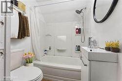 Bathroom featuring shower / bath combination with curtain and vanity - 