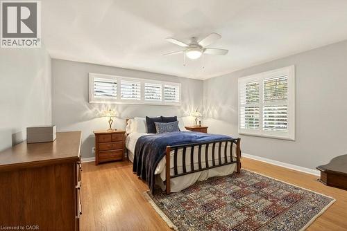 Hardwood floors & 2 walls with windows w/ California shutters - 29 Woodside Drive, Hamilton, ON - Indoor Photo Showing Bedroom