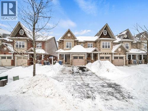 View of front of house featuring covered porch, a garage, and stone siding - 29 Amsterdam Crescent, Guelph, ON - Outdoor With Facade