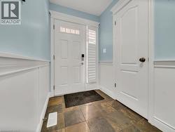 Foyer with a wainscoted wall, a decorative wall, and stone tile floors - 