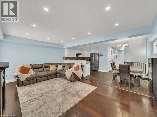Living area featuring dark wood-style flooring, a tray ceiling, recessed lighting, and a chandelier - 29 Amsterdam Crescent, Guelph, ON - Indoor Photo Showing Living Room