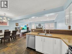 Kitchen featuring stone tile floors, white cabinetry, appliances with stainless steel finishes, open floor plan, and a peninsula - 