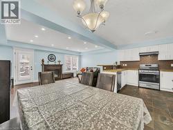 Dining room with recessed lighting, a glass covered fireplace, a chandelier, plenty of natural light, and dark stone finish flooring - 