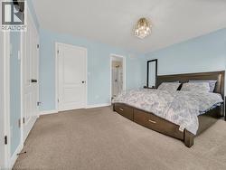Carpeted bedroom featuring a chandelier and connected bathroom - 