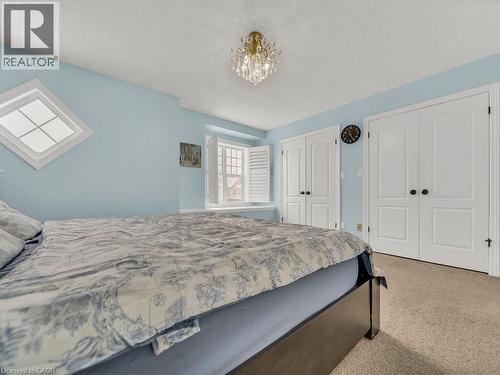 Bedroom with two closets, carpet, a textured ceiling, and a chandelier - 29 Amsterdam Crescent, Guelph, ON - Indoor Photo Showing Bedroom