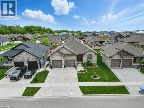 View of front of property with driveway, a garage, a residential view, and a shingled roof - 107 Forbes Crescent, Listowel, ON - Outdoor With Facade