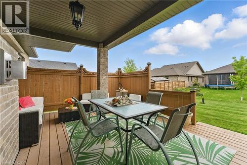 Wooden terrace with outdoor dining area, a fenced backyard, and a trampoline - 107 Forbes Crescent, Listowel, ON - Outdoor With Deck Patio Veranda With Exterior