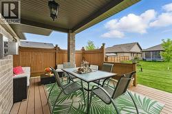 Wooden terrace with outdoor dining area, a fenced backyard, and a trampoline - 
