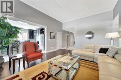 Living room featuring crown molding, wood finished floors, and recessed lighting - 