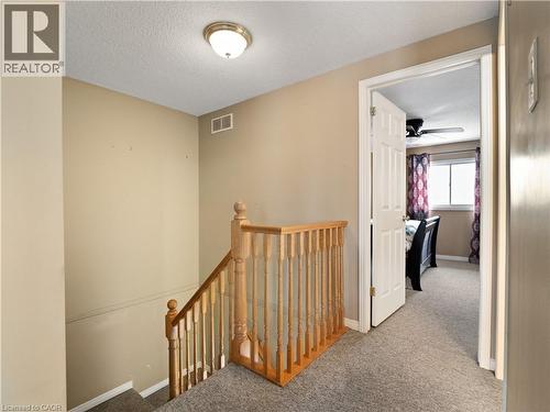 Hall with an upstairs landing, a textured ceiling, and carpet flooring - 47 Schroder Crescent, Guelph, ON - Indoor Photo Showing Other Room