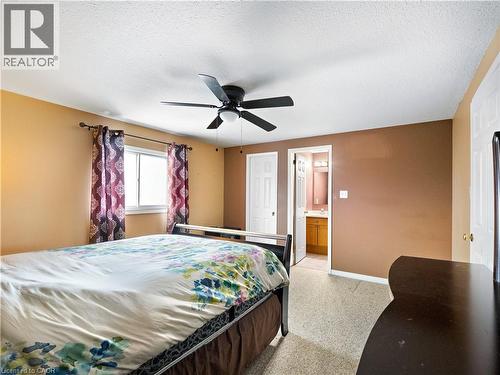 Bedroom featuring ensuite bath, a ceiling fan, a textured ceiling, and light carpet - 47 Schroder Crescent, Guelph, ON - Indoor Photo Showing Bedroom