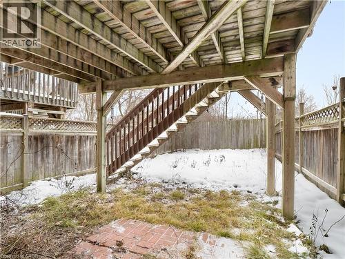 Snow covered patio with a fenced backyard and stairway - 47 Schroder Crescent, Guelph, ON - Outdoor