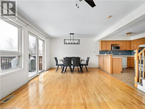 Kitchen featuring light wood-style floors, a peninsula, hanging light fixtures, light countertops, and a ceiling fan - 47 Schroder Crescent, Guelph, ON - Indoor