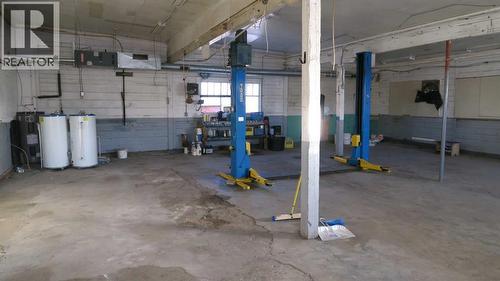 Concrete Floor With Hoist - 208 4 Avenue, Gleichen, AB - Indoor Photo Showing Garage
