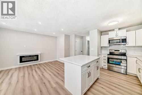 937 Marcombe Drive Ne, Calgary, AB - Indoor Photo Showing Kitchen With Fireplace