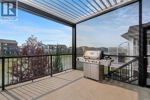 This custom, extended back deck impresses with natural sunlight and sun coast screens - 2253 Bayside Road Sw, Airdrie, AB - Outdoor With Exterior