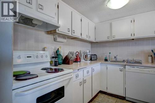 White kitchen with white appliances - 602, 2200 Woodview Drive Sw, Calgary, AB - Indoor Photo Showing Kitchen