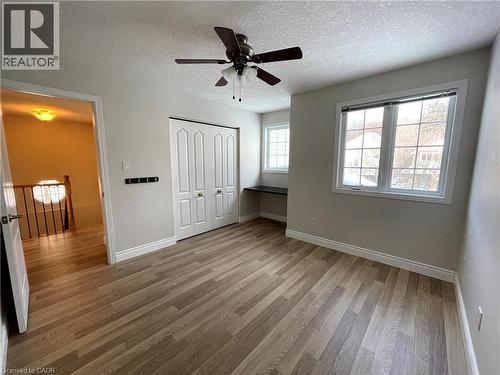 Unfurnished bedroom with light wood finished floors, a textured ceiling, ceiling fan, and a closet - 443 Lausanne Crescent, Waterloo, ON - Indoor Photo Showing Other Room
